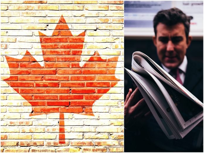 Canadian flag maple leaf on a brick wall and a man reading a newspaper